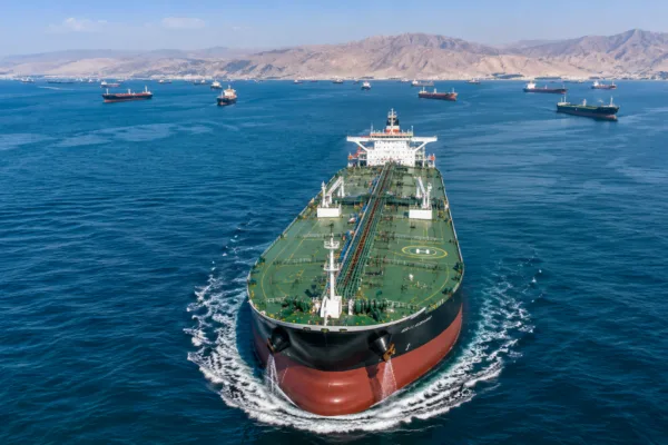 Large crude oil tanker sailing through the Strait of Hormuz as U.S. sanctions relief unlocks Iranian oil exports and billions in potential revenue for Tehran.
